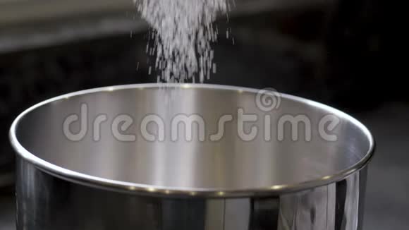女性手在碗中用筛子筛面粉的慢动作视频的预览图