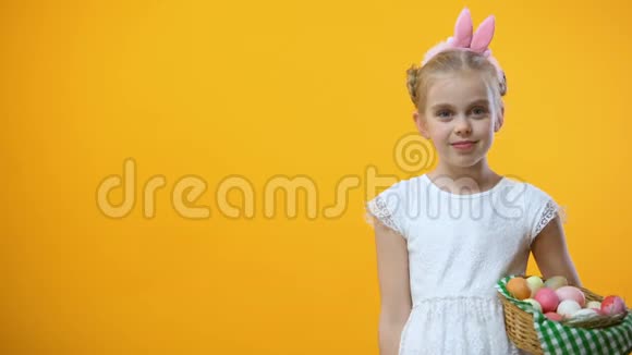 戴着兔耳朵头巾的女孩子拿着复活节篮子竖起大拇指视频的预览图