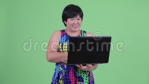 快乐年轻体重超重的亚裔女性使用笔记本电脑思考问题视频的预览图