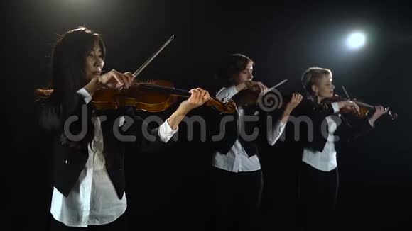 三个女孩在一个房间里演奏小提琴黑色背景视频的预览图