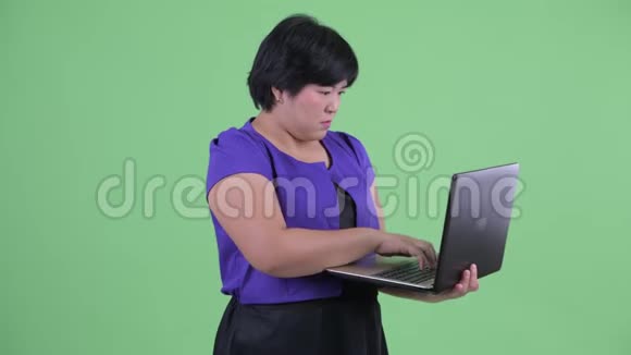 快乐年轻体重超重的亚裔女性使用笔记本电脑思考问题视频的预览图