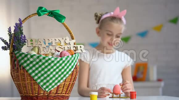 学校女生绘画把彩蛋放进篮子里节日气氛视频的预览图