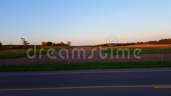 日落时美丽的乡村农田带照相机黄昏时风景秀丽的乡村农场视频的预览图