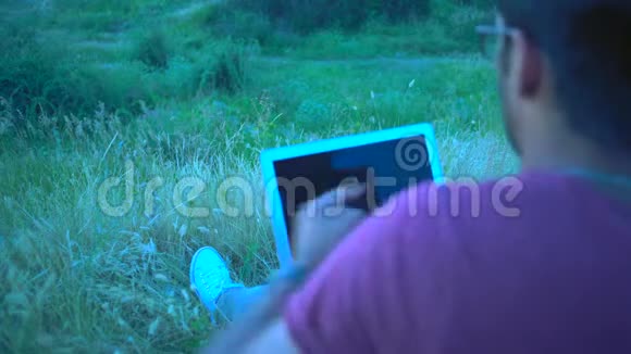 特写镜头笔记本电脑屏幕上的倒影印度男性在电话上有感情地交谈跪在笔记本电脑里视频的预览图