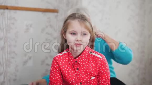 祖母给孙女们梳头穿红衬衫的女孩视频的预览图