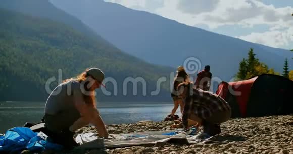 一群徒步旅行者在河边搭建帐篷视频的预览图
