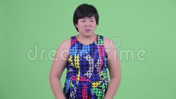 年轻体重超重的亚洲女人在往下看视频的预览图