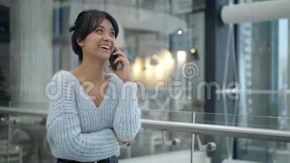 中档亚洲女性走路时在电话中笑视频的预览图
