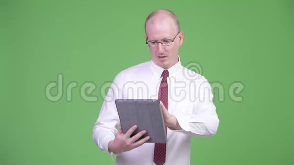 快乐成熟的秃头商人使用数码平板电脑得到好消息视频的预览图