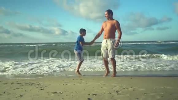 年轻的父亲和他的儿子在海滩上骑马阳光灿烂爸爸和儿子都很高兴信托关系视频的预览图