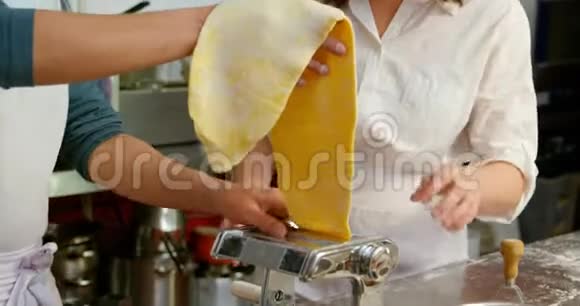 男女面包师使用厨房4k的意大利面切割机视频的预览图