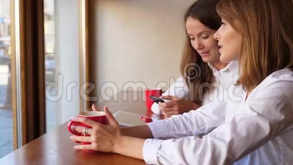 两个年轻的女职员在办公室喝咖啡视频的预览图