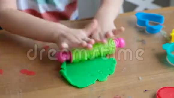 可爱的4岁男孩在家玩面团双手合拢视频的预览图