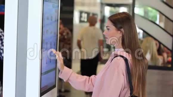 一位女士在快餐店用电子菜单在触摸屏终端点菜视频的预览图