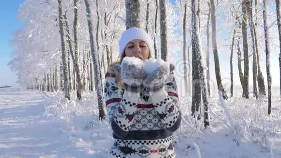 女人把手套上的雪吹下来然后把它扔起来站在雪下视频的预览图