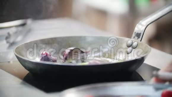 厨师是在煎锅里在厨师的手里炒洋葱视频的预览图