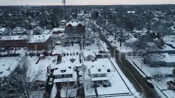 在寒冷的冬日一个被雪覆盖的小镇的空中景色视频的预览图