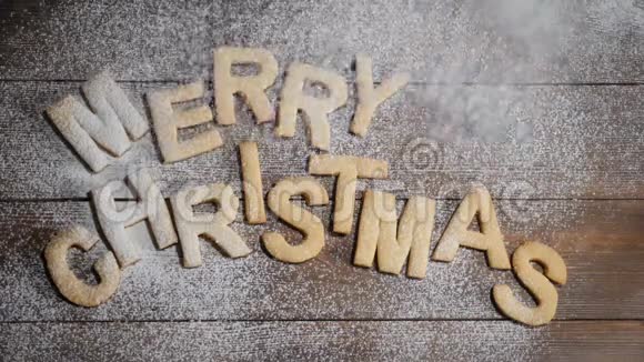新年快乐圣诞快乐纸条上面写着棕色木制背景的饼干字母白色粉末视频的预览图