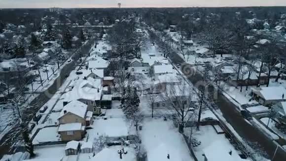 在寒冷的冬日一个被雪覆盖的小镇的空中景色视频的预览图
