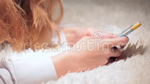 年轻女子手机打印短信羊毛背景高清镜头视频的预览图