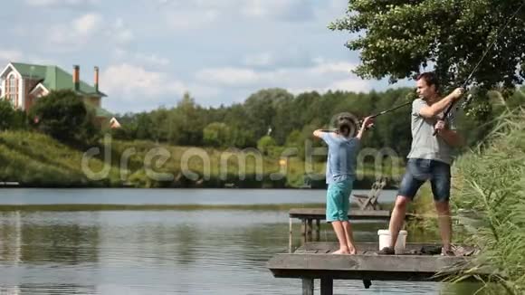爸爸和十几岁的男孩一起在湖边钓鱼视频的预览图