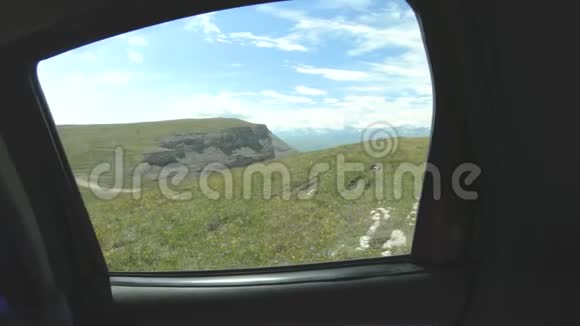在阳光明媚的日子里从车上看到高原的自然景观在山上很高公路旅行视频的预览图