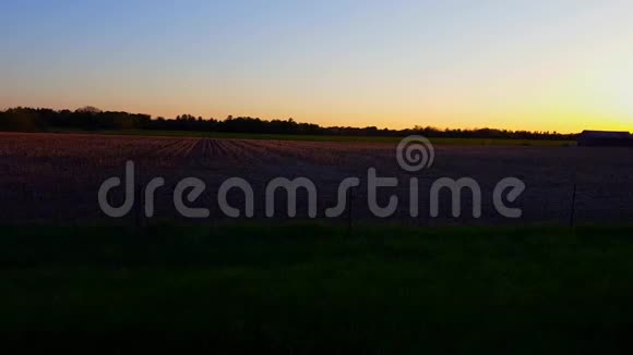 日落时美丽的乡村农田带照相机黄昏时风景优美的乡村农场视频的预览图