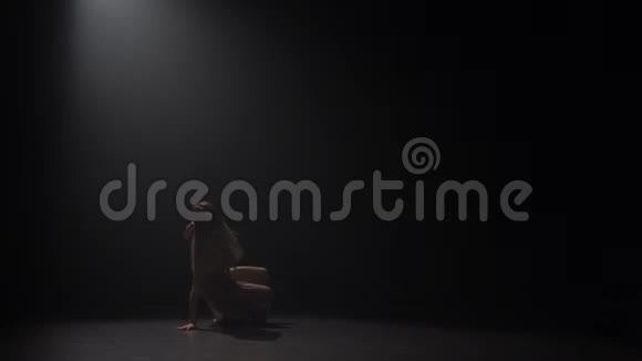在黑暗的工作室里美丽的少女跳舞的慢动作视频的预览图