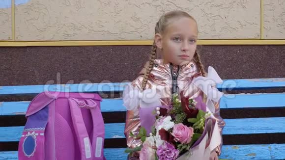 愤怒的女学生拿着花束和背包坐在长椅上哭泣视频的预览图