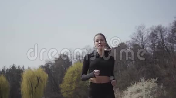漂亮苗条的年轻女子穿着运动服在河岸上奔跑积极的生活方式运动女人把她的身体视频的预览图