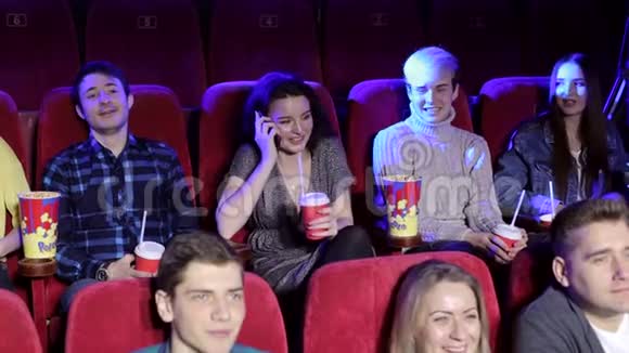 粗鲁的女人在电话里说话在电影院里打扰其他观众视频的预览图