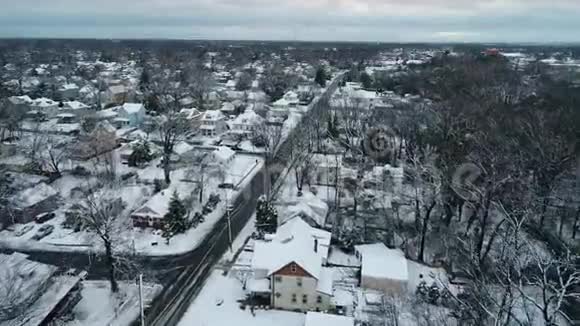 在寒冷的冬日一个被雪覆盖的小镇的空中景色视频的预览图