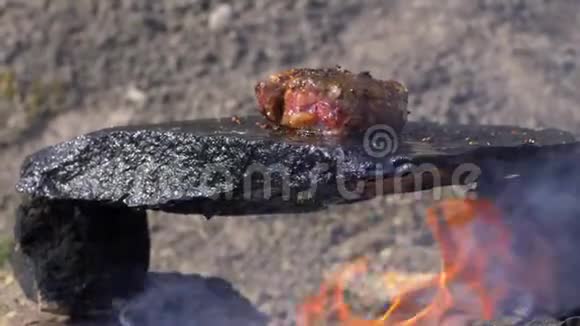 吃有机肉在热石上烤出多汁的牛排把融化的脂肪和油淋在火上视频的预览图