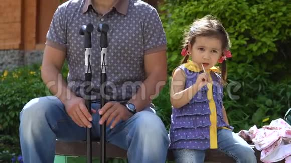 一个男人和一个小女孩坐在长凳上视频的预览图