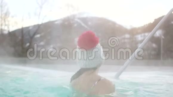 温泉度假村在山区的地热源冬天在室外游泳池里泡妞视频的预览图