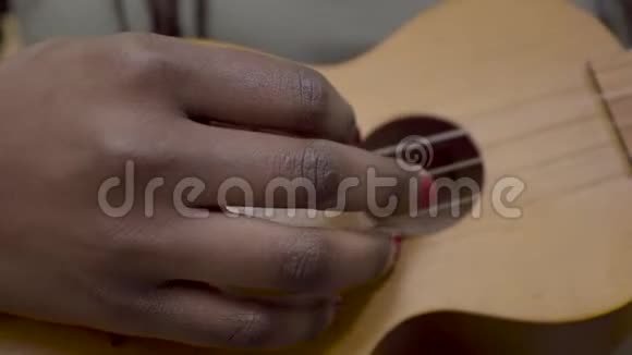 非洲裔美国人女性手将演奏新的四弦琴吉他或准备开始学习乐器关门视频的预览图