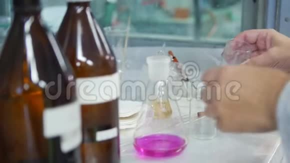 一个女人把紫色液体和化学物质混合到烧瓶里视频的预览图