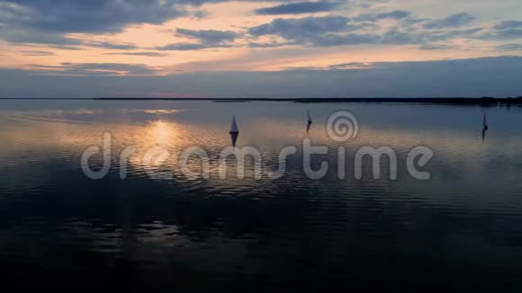 空中无人机拍摄的和平场景与游艇巡航在平静的水在黄昏视频的预览图