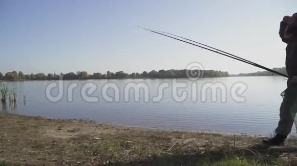 长胡子的渔夫拿着钓竿和埋伏圈网在河边散步慢动作视频的预览图