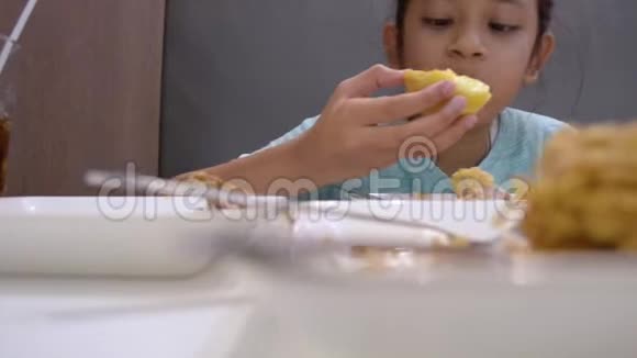 可爱的女孩在午餐时间在桌子上吃一些食物的肖像视频的预览图
