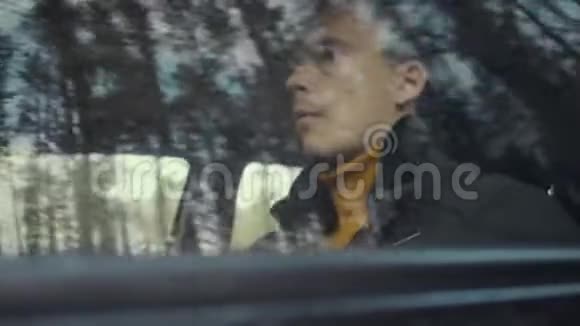 人骑着一辆车在乡间小路上车窗上的树木视频的预览图