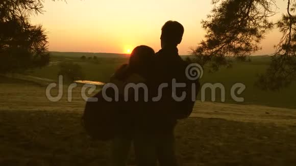 女孩和男人旅行在森林里散步在日落时欣赏风景情侣旅行者带着背包旅行幸福家庭视频的预览图