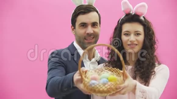 家人庆祝复活节有兔子耳朵的快乐夫妻节日快乐一对复活节彩蛋装饰视频的预览图
