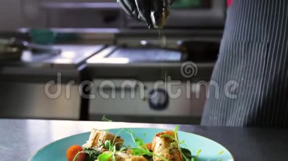 厨师在成品菜上撒上三文鱼和菠菜酱视频的预览图