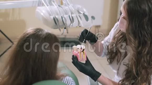 一名牙医对坐在椅子她的病人解释说一名牙医对一名妇女进行了缓慢射击的特写镜头视频的预览图