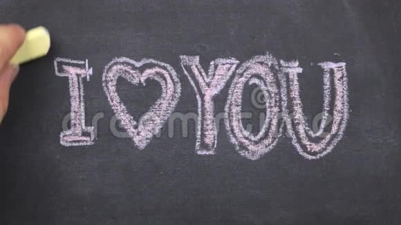小黑板上写着我爱你的文字用粉笔写在上面用粉笔沿轮廓划动视频的预览图