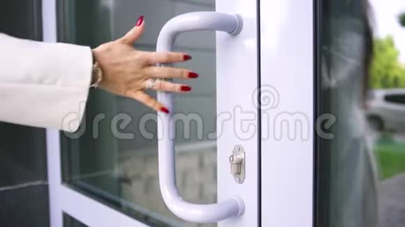 用漂亮的戒指关上女人的手看着她的手腕和红色的指甲打开大楼的门艺术视频的预览图