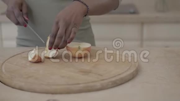 美国黑人妇女用锋利的大刀把木板上的苹果切成碎片健康食品视频的预览图