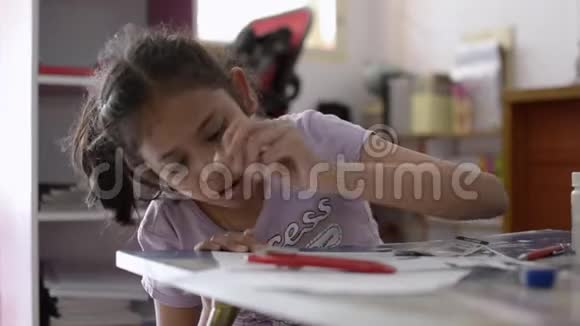 小亚洲女孩在家里的书桌上做作业视频的预览图