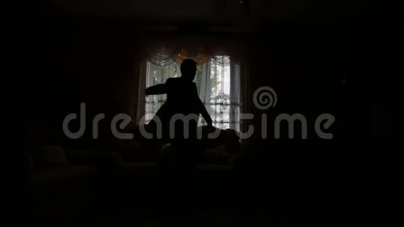 男人穿着黑色夹克站在窗前视频的预览图